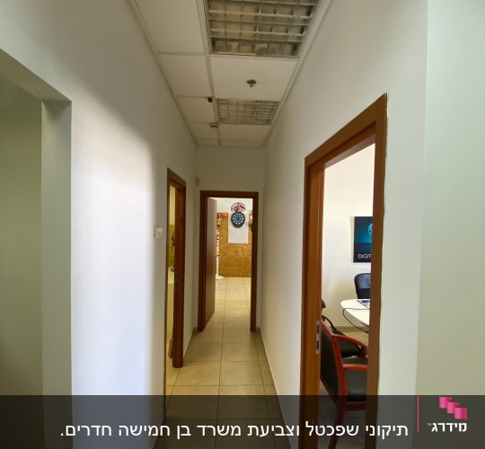 מסדרון עם קירות לבנים ודלתות עץ